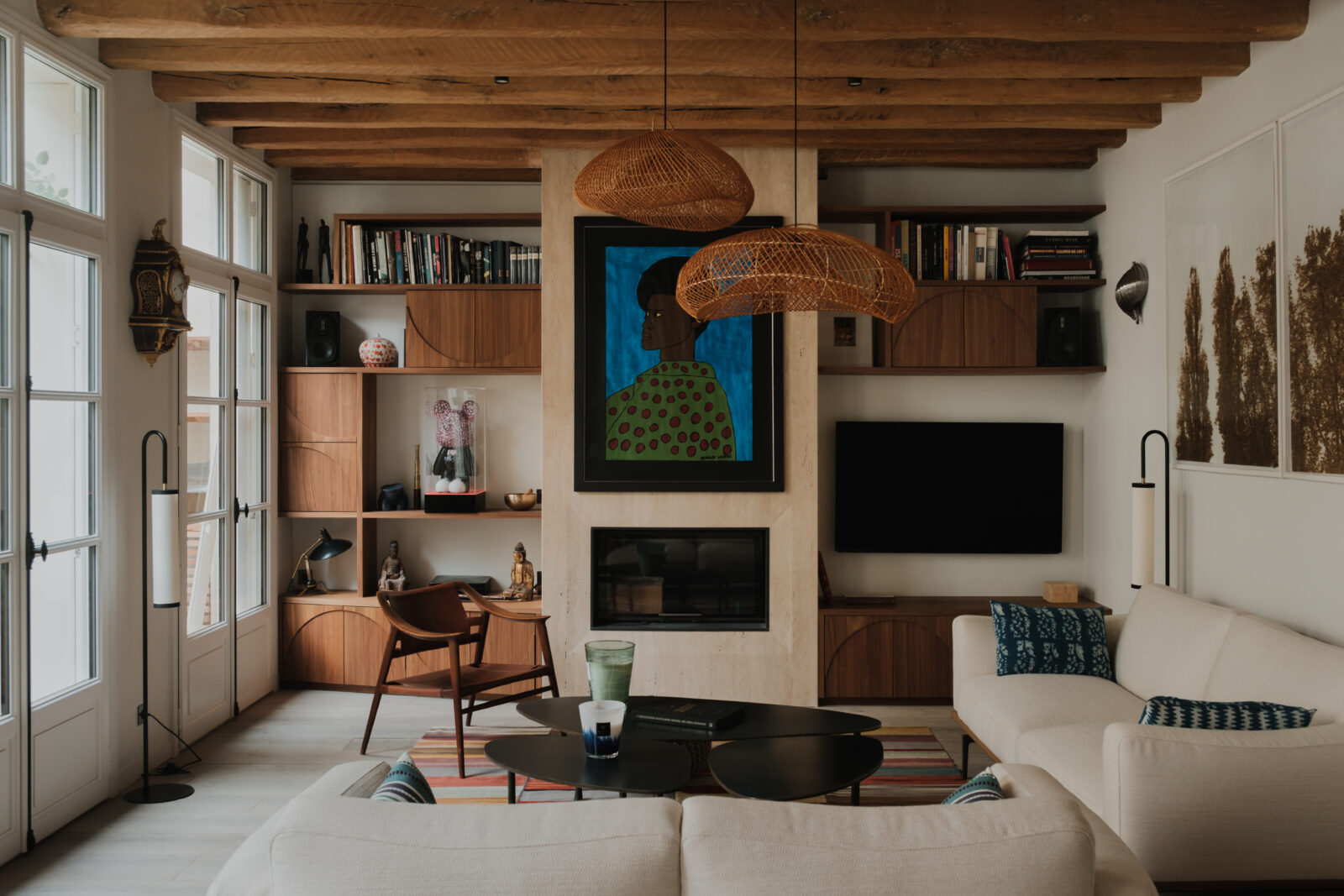 Salon avec poutres apparentes, bibliothèque sur mesure en noyer et cheminée en pierre, appartement rénové à Saint-Germain